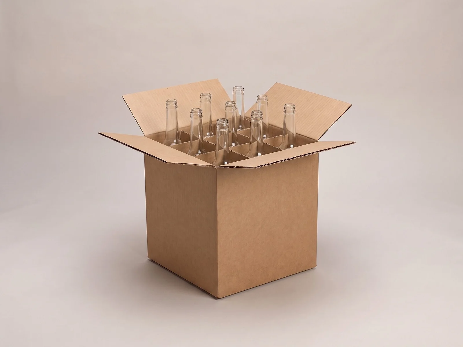 Caja de cartón con divisiones que separan botellas de vidrio sin etiqueta